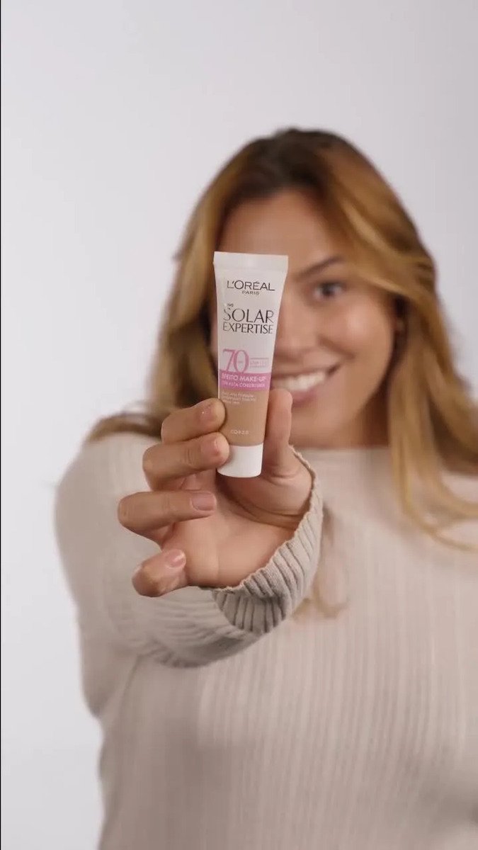 Protetor solar L’Oréal Solar Expertise Efeito Make-Up FPS 70 cor 4.0 na mão de uma modelo